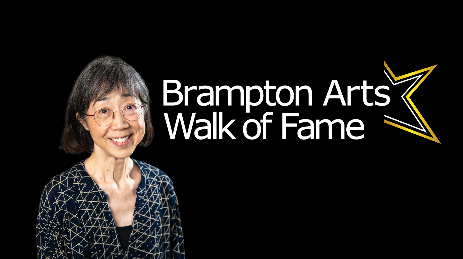 A smiling older woman with short gray hair and glasses stands against a black background, wearing a patterned black top. To her right is the text “Brampton Arts Walk of Fame” alongside a gold star graphic.